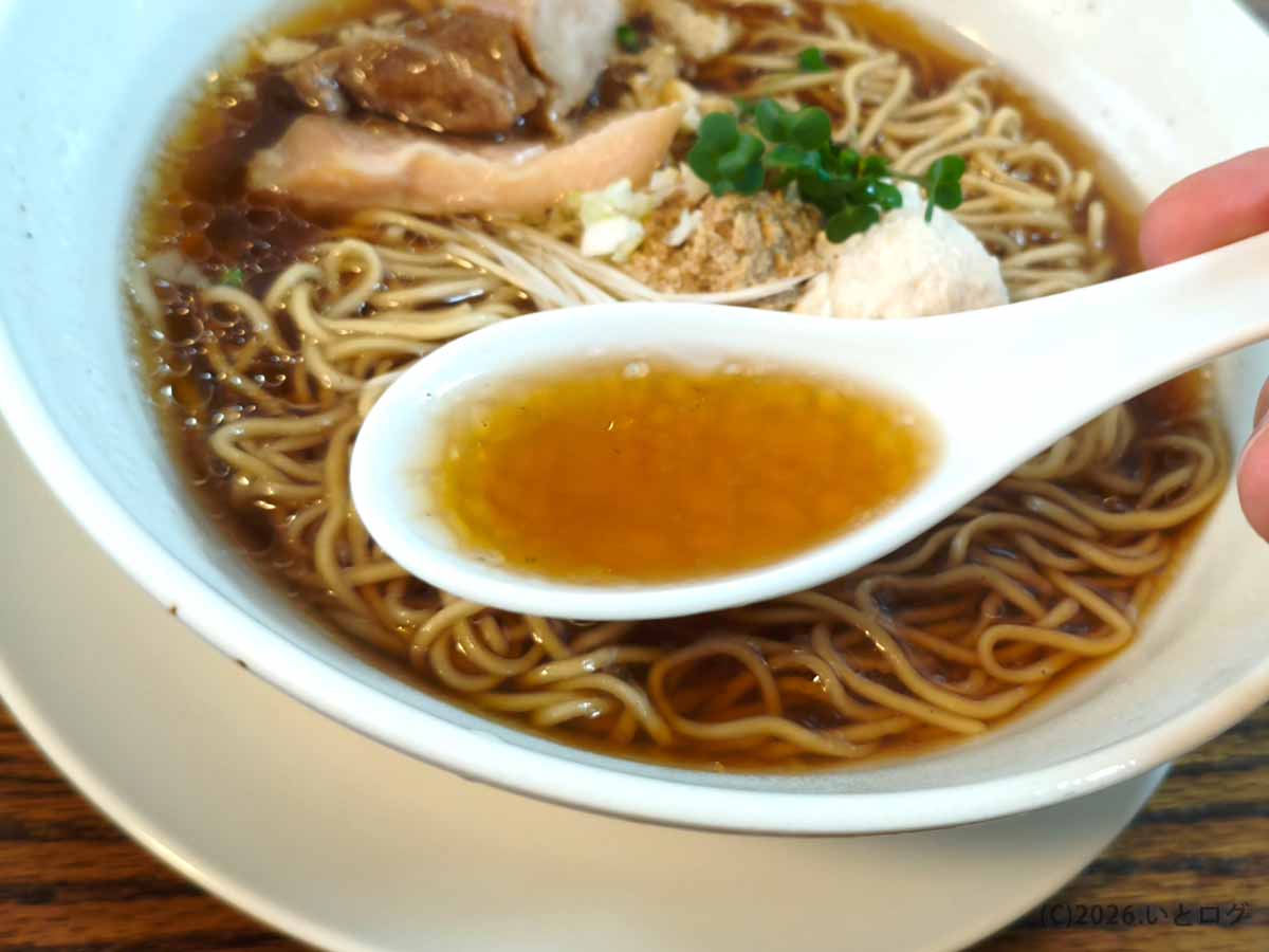 富士吉田「とりそば ささ」のとりそばしょうゆからレンゲですくった茶褐色のスープ