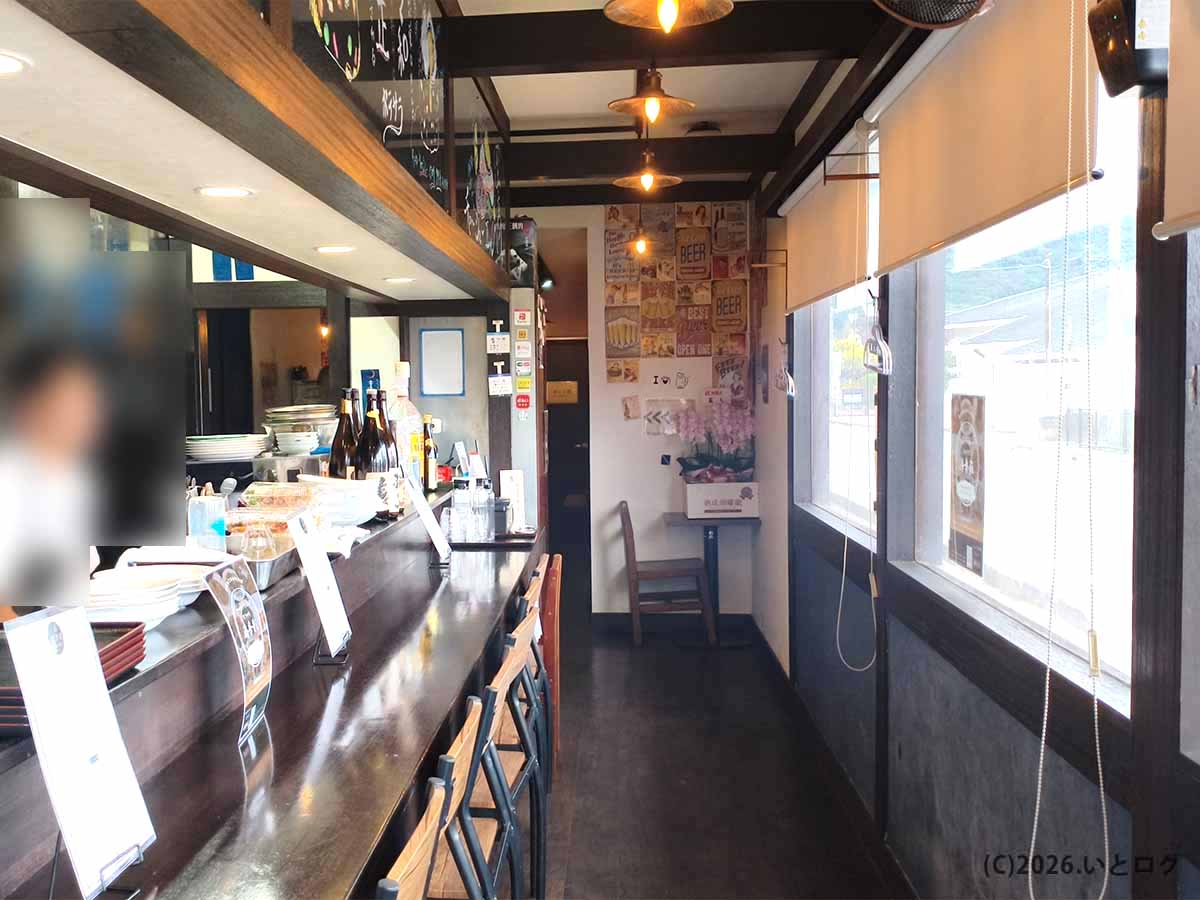 甲府市の町中華ダイニング蒔季彩の店内。厨房前にカウンター席が並ぶ落ち着いた雰囲気