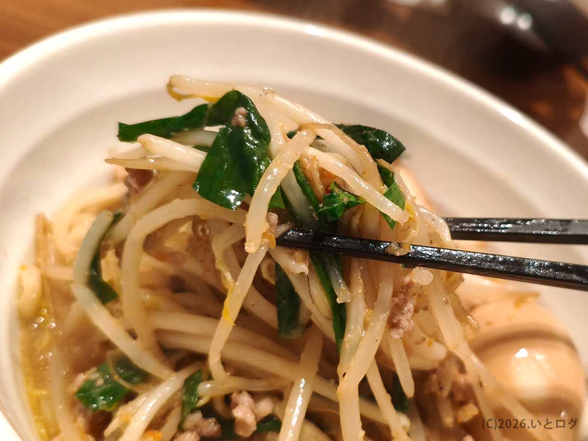 町中華ダイニング蒔季彩の味噌ラーメンに盛られた炒めもやしとニラを箸で持ち上げた様子