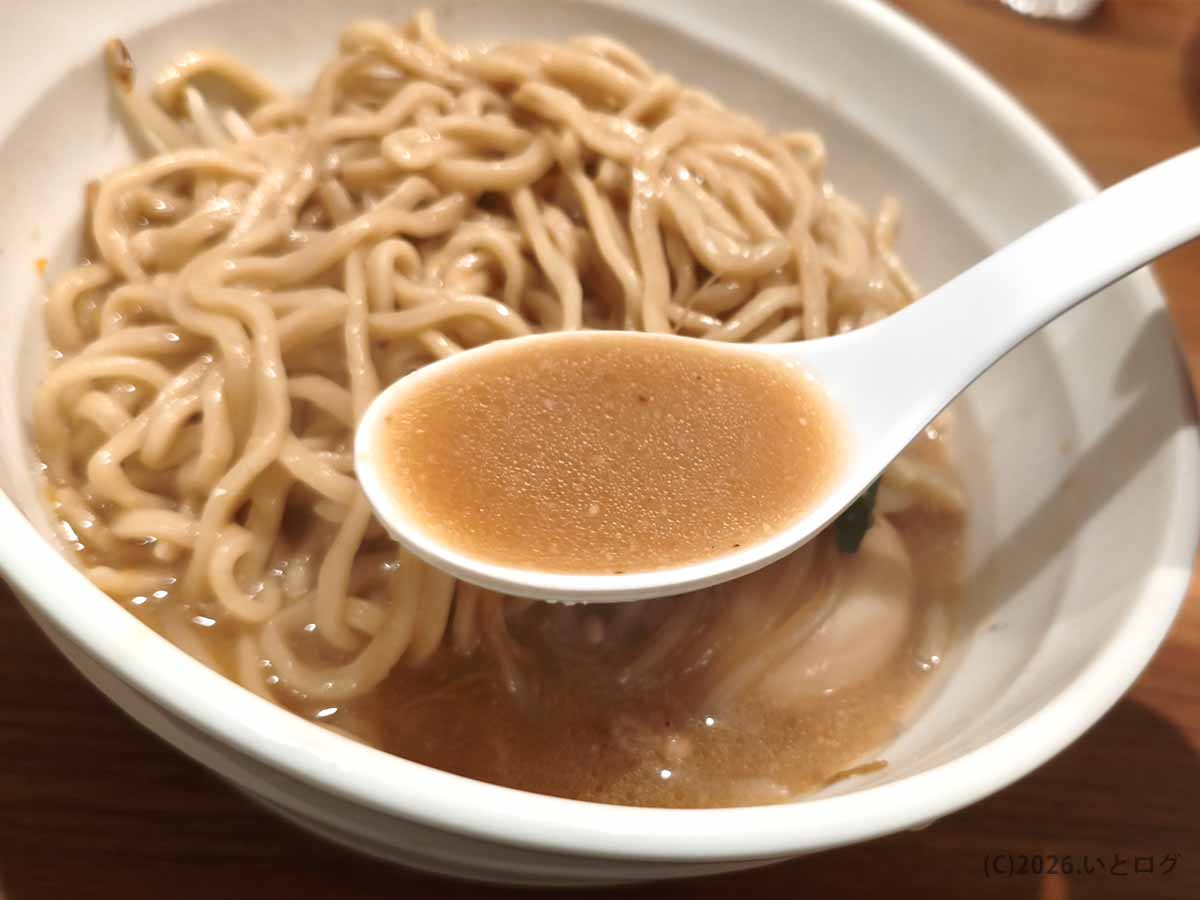 甲府市の町中華ダイニング蒔季彩で提供される味噌ラーメンの味噌スープをレンゲですくった様子