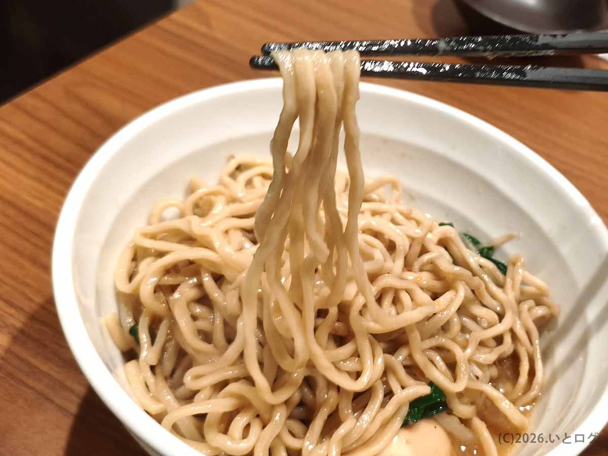 甲府の町中華ダイニング蒔季彩の味噌ラーメン。太めの麺を箸で持ち上げた様子