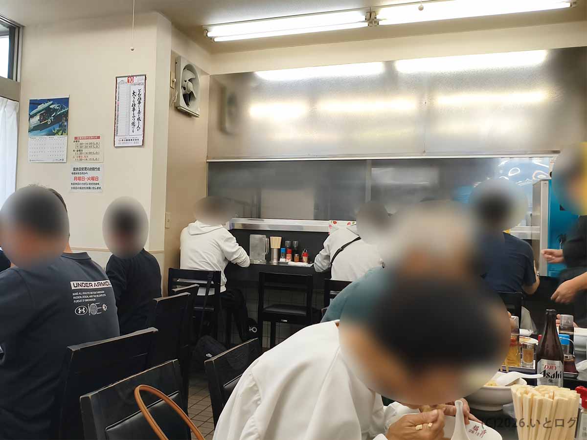 山梨県甲府市の中華 福吉の店内。カウンター席やテーブル席が並び、昼食を楽しむお客さんでにぎわう様子
