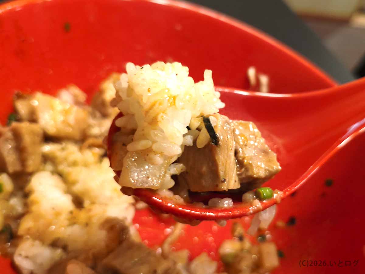 甲府市あぶらギルドの油そばを食べ終えた後の追い飯。赤いレンゲにご飯とチャーシューをのせ、残った特製ダレを絡めて楽しむ締めの一口。