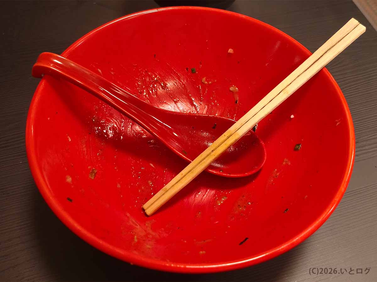 山梨県甲府市のあぶらギルドでBトッピング油そば大盛り300gを完食した後の赤い丼。箸とレンゲが置かれ、最後まで食べ終えた様子がわかる。
