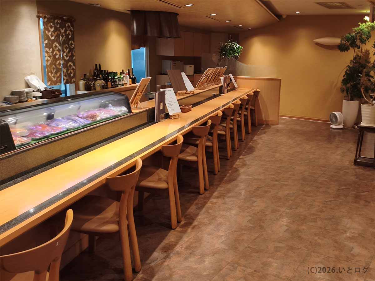 山梨県昭和町の二代目たわらの店内。鮮魚が並ぶガラスケースに沿って木製のカウンター席が設けられている