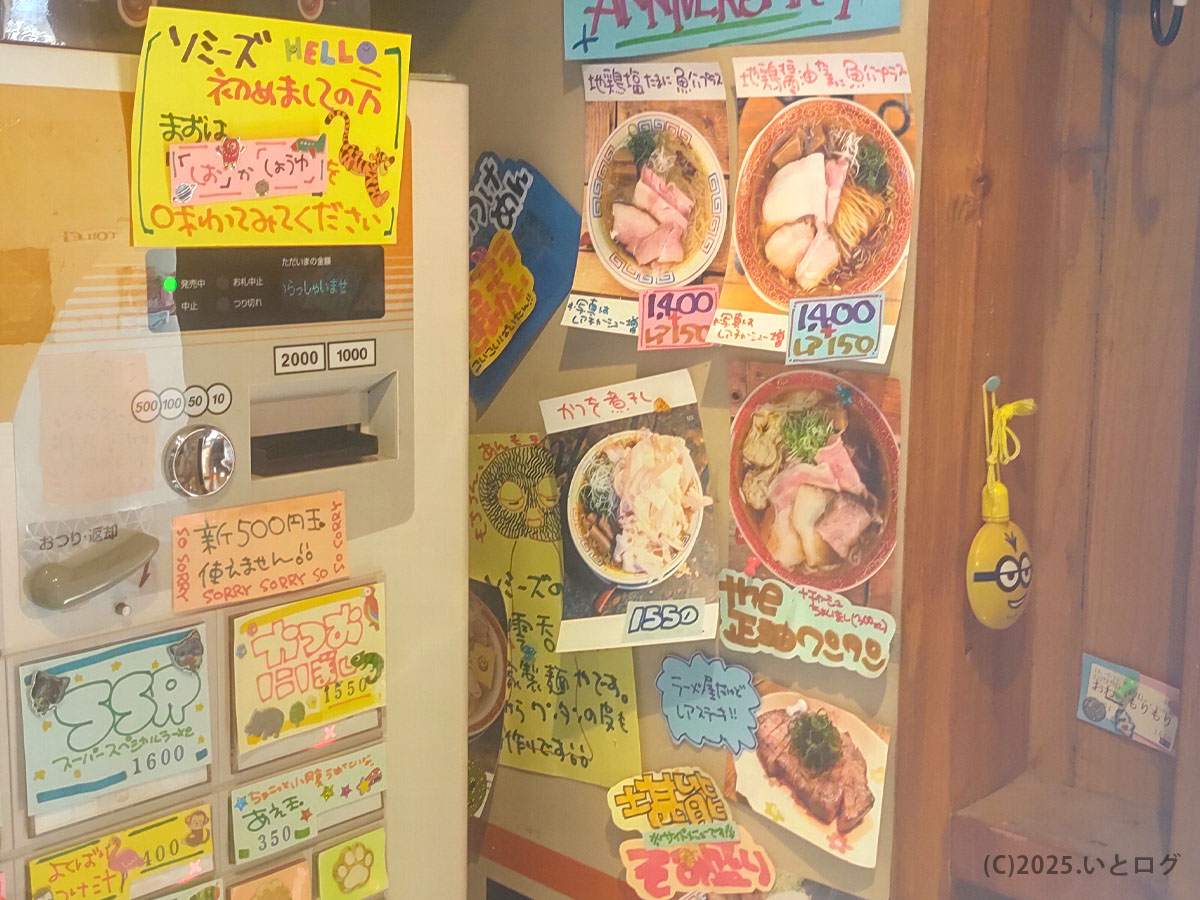 麺屋Somie'sの券売機と壁メニュー。人気のしょうゆラーメンや限定メニューが写真付きで紹介され、福知山ラーメンレビューにも役立つ。
