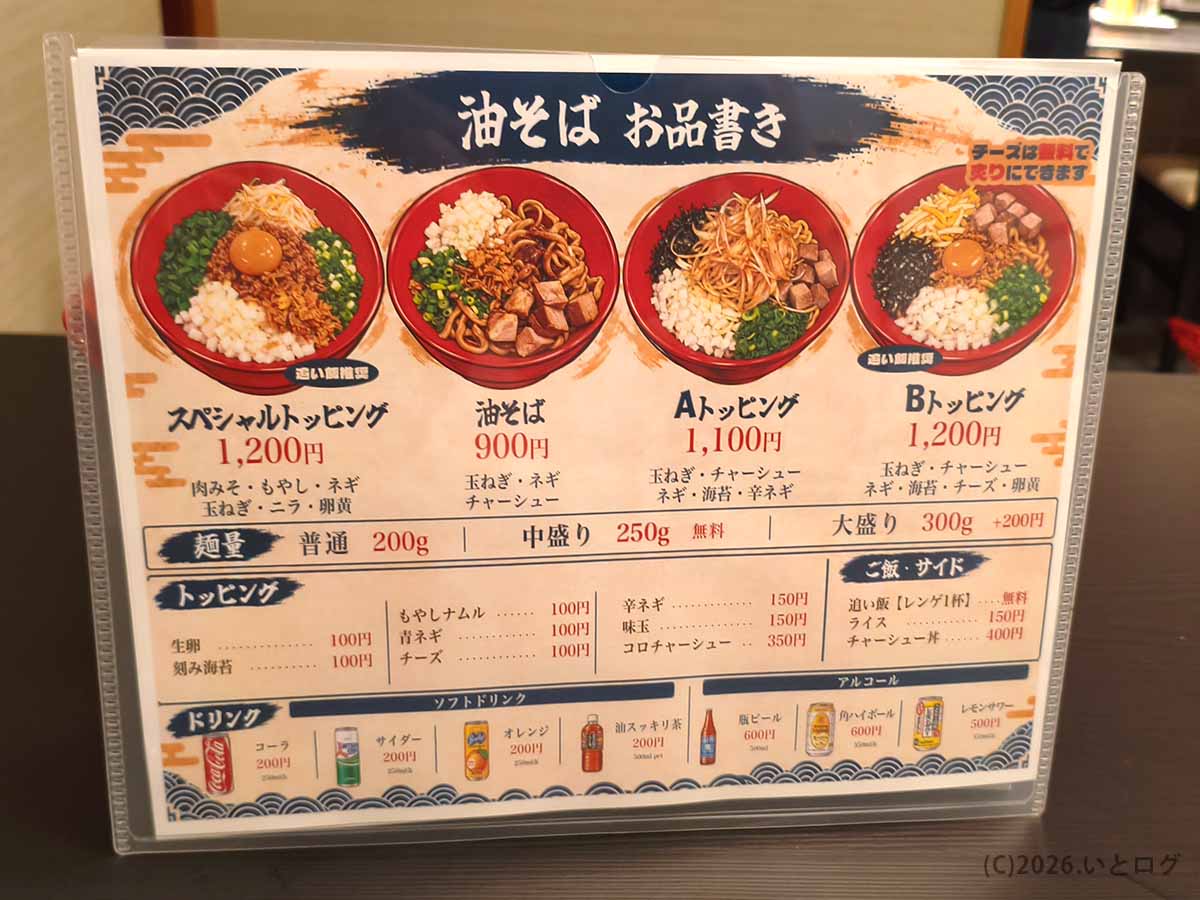 甲府市の油そば専門店あぶらギルドのメニュー表。油そば900円、Aトッピング1100円、Bトッピング1200円などの種類と麺量、追加トッピング、サイドメニューの料金を掲載。