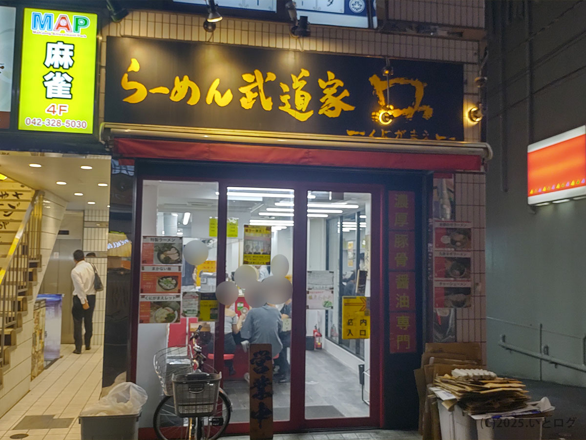 武道家 口(くにがまえ)国分寺店の外観。国分寺駅からすぐの場所にあり、夜でも明るい赤い入口が目印。家系ラーメンを求めて訪れる人が絶えない人気店。