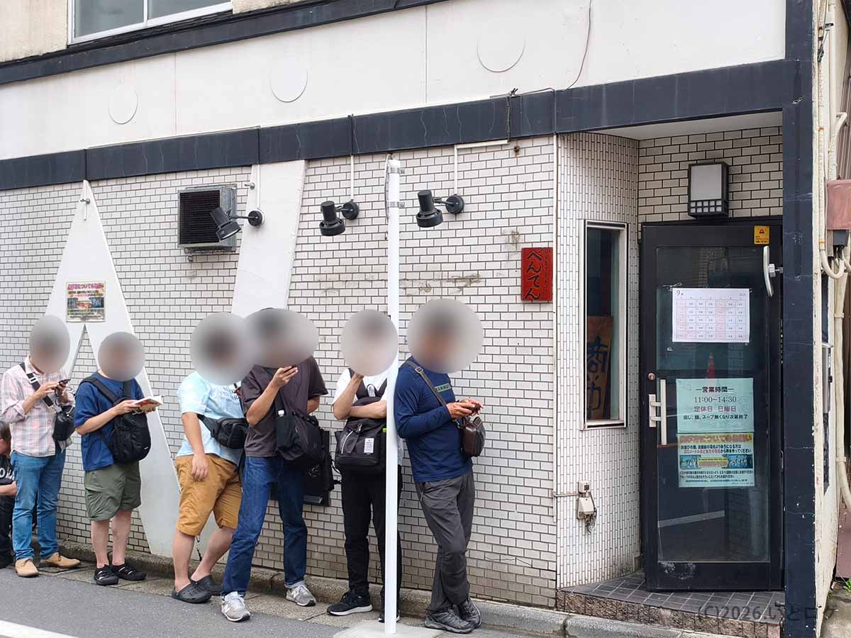 東京都練馬区旭町にある中華そば べんてんの外観。白いタイル張りの店舗前にラーメンを待つ客が並ぶ様子