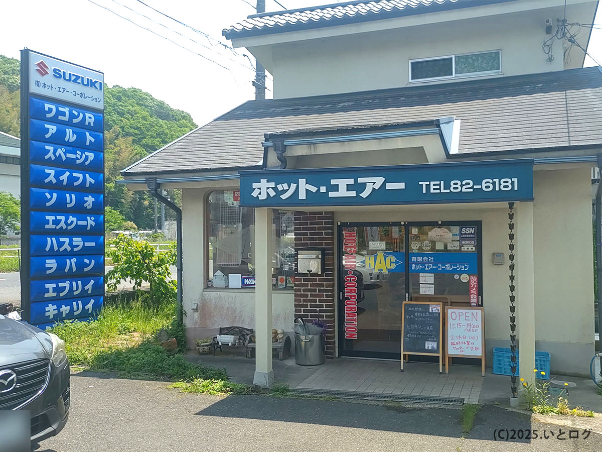ホットエアーコーポレーションの建物に併設されたラーメン店ホットエアー。自動車販売の看板と並ぶユニークなミシュラン掲載店。
