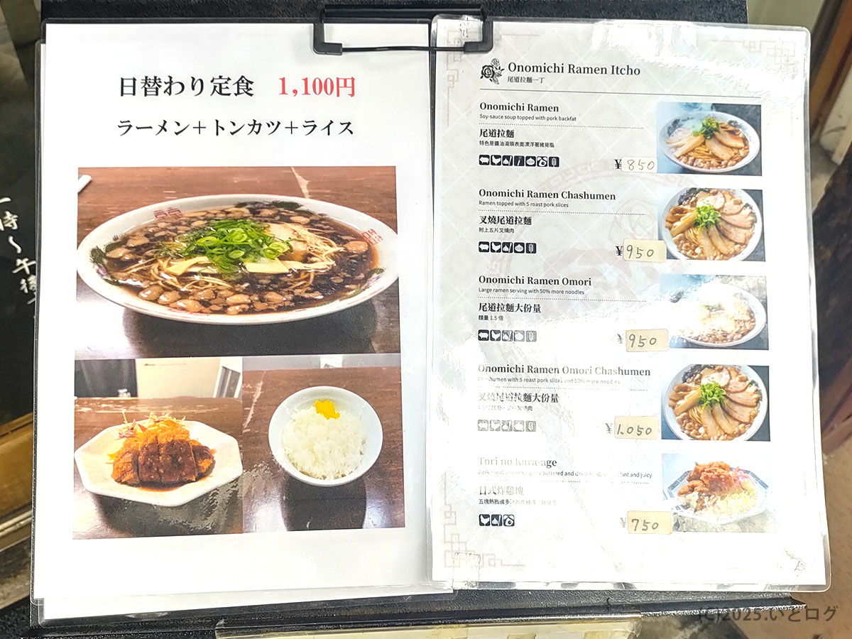尾道ラーメン一丁のメニュー表。ラーメン+トンカツ+ライスの「日替わり定食(1,100円)」や、英語表記付きのレギュラーメニューが並ぶ。Onomichi Ramen Ichouらしい親切な案内で、福山観光客にも人気。