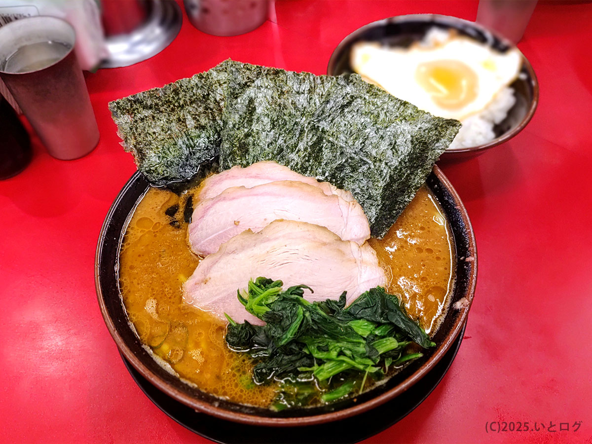 「赤いカウンターに映えるIEKEI TOKYOの家系ラーメン。王道家直系らしい濃厚スープに海苔・ほうれん草・大判チャーシューがのり、ライスや目玉焼き丼との組み合わせも人気。