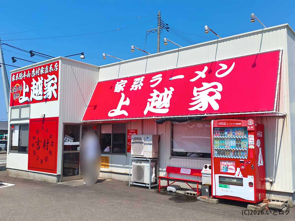 新潟県上越市にある吉村家直系家系ラーメン「上越家」の赤い看板と店舗外観