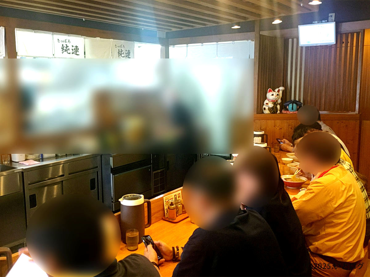 さっぽろ純連 仙台店の店内カウンター席の様子。活気ある雰囲気の中、多くの人が味噌ラーメンを楽しんでいる様子が伝わる。