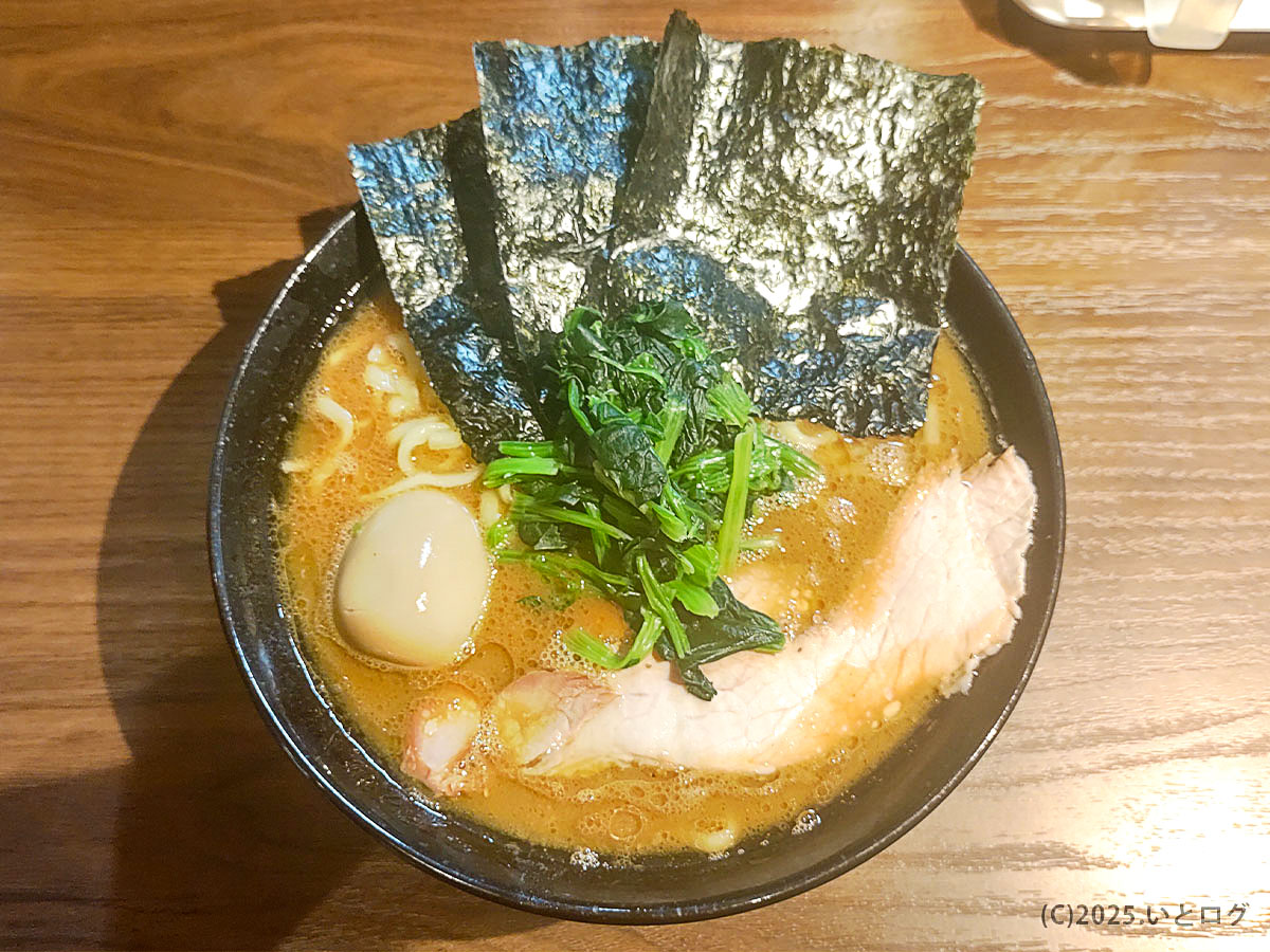 輝道家 水道橋店のラーメン。濃厚豚骨醤油スープに中太麺、海苔、ほうれん草、チャーシュー、味玉がのる家系ラーメンの王道スタイル。