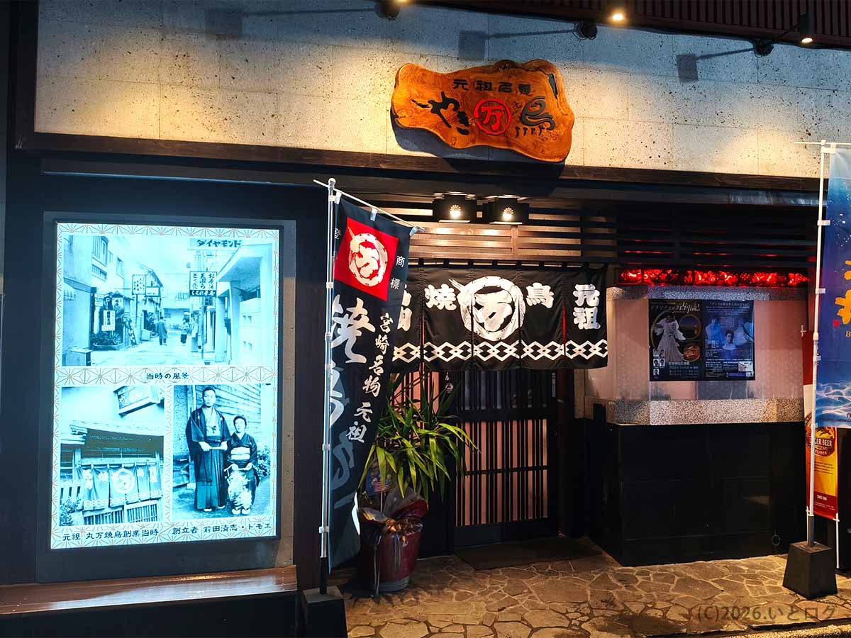 宮崎市にある丸万焼鳥 支店の店舗外観。元祖焼鳥丸万の看板とのれんが掲げられた入口