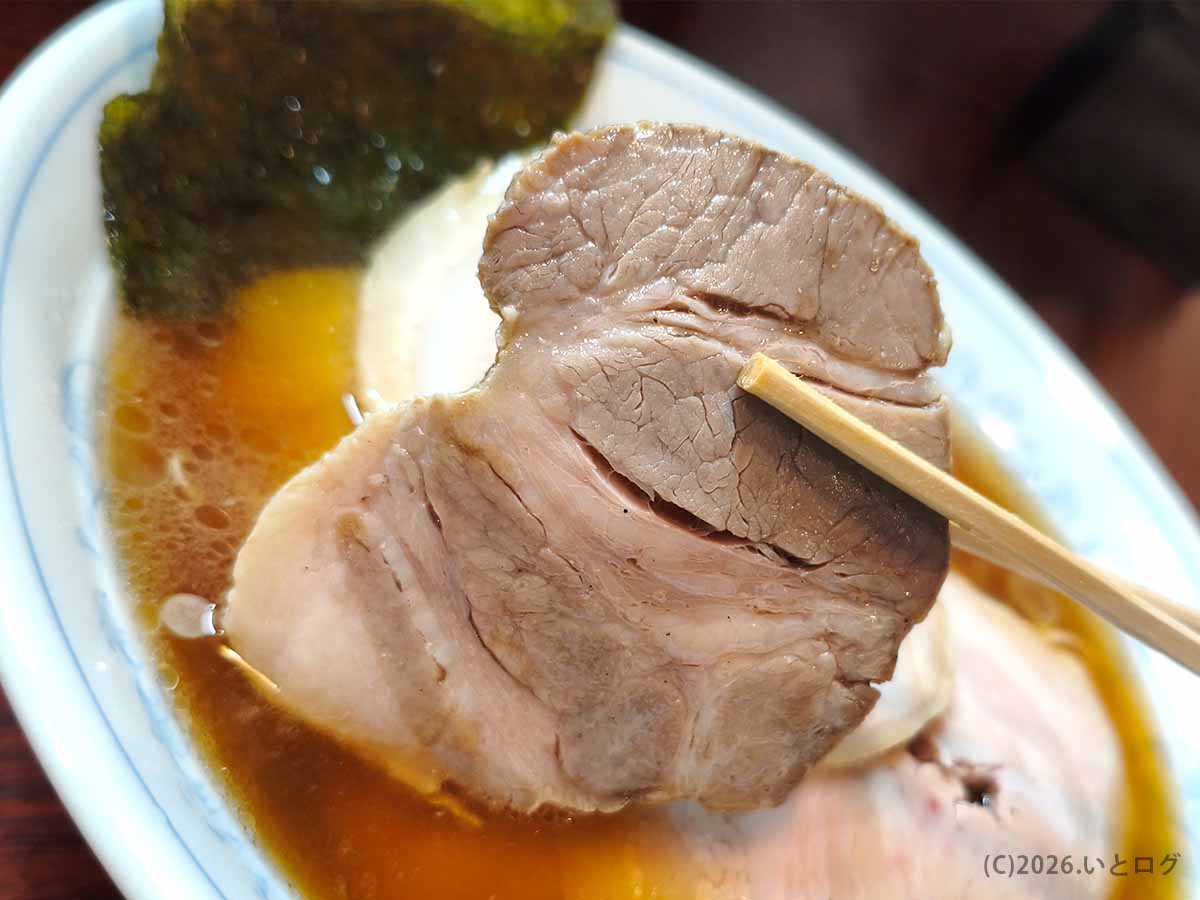 甲府市「麺どころ 千石」のラーメンにのる肉厚チャーシューを箸で持ち上げた様子