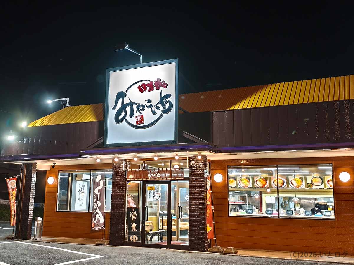 夜に撮影した、山梨県甲斐市龍地にあるラーメン店みやこいち 双葉店の店舗外観と駐車場