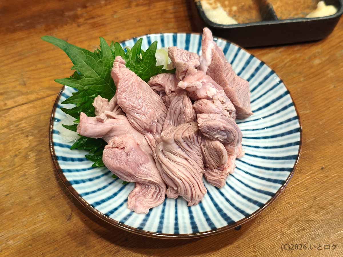 立川の美の田で注文した、湯引きしたもつを大葉と玉ねぎの上に盛り付けたもつ刺し