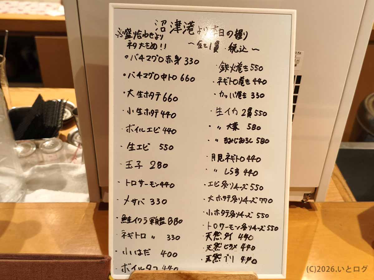 二代目たわらの本日の握り寿司メニューを記したホワイトボード。バチマグロ、中トロ、ホタテ、海老、ウニなどの寿司ネタと一貫ごとの価格が手書きされている