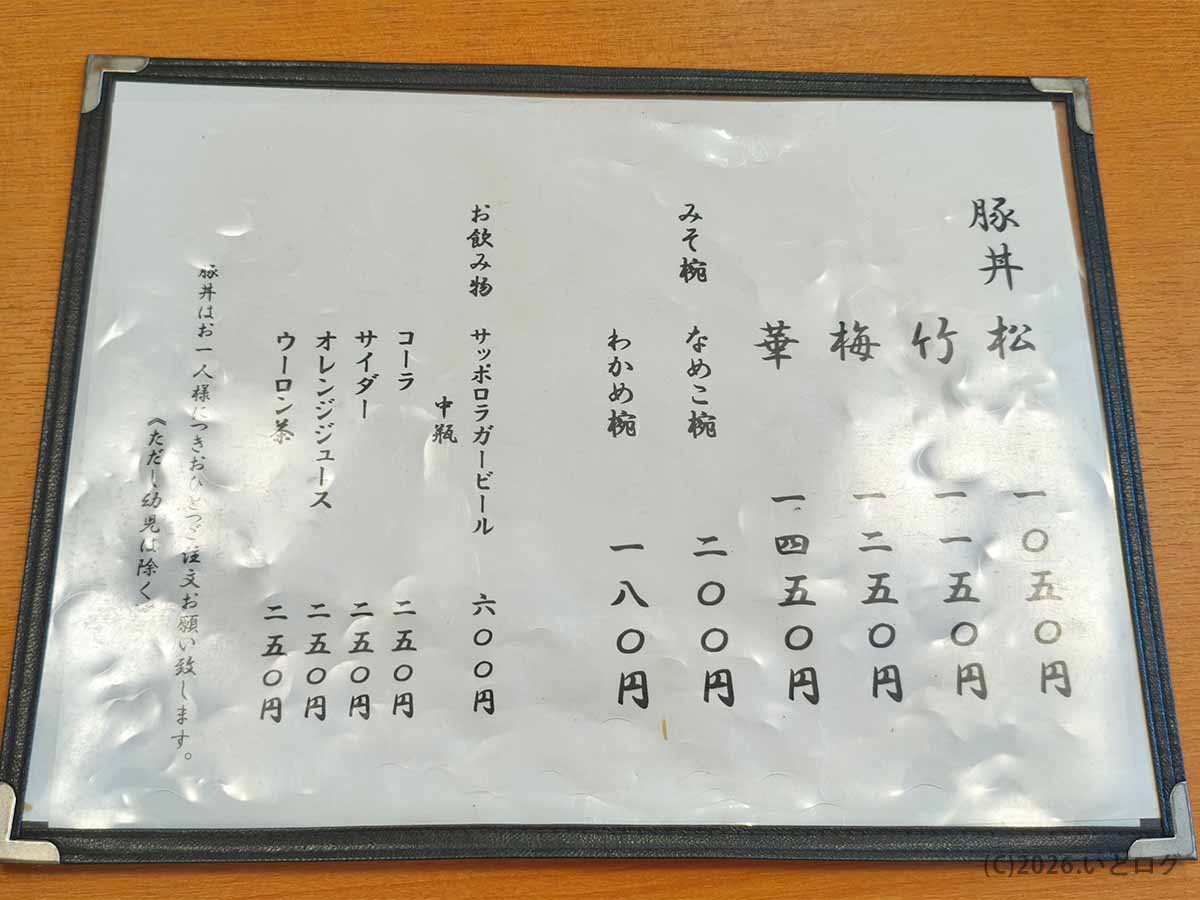 元祖豚丼のぱんちょうの店内メニュー表。豚丼の松1050円、竹1150円、梅1250円、華1450円のほか、なめこ椀や飲み物の価格が掲載されている。