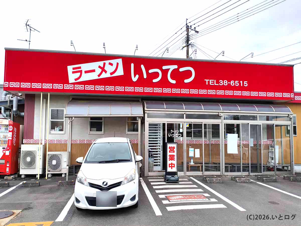 宮崎県都城市にあるラーメンいってつの店舗外観。赤い看板と店前の駐車スペースが目印