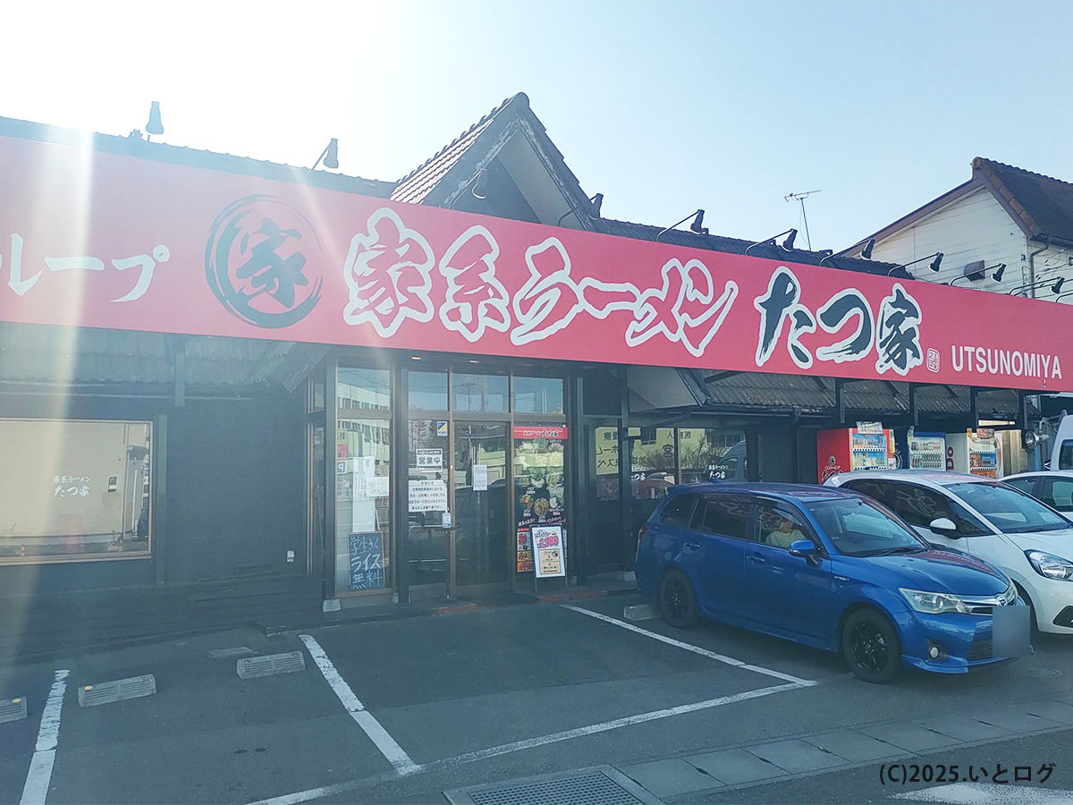 宇都宮の家系ラーメン『たつ家』外観。王道家DNAの赤い看板と店舗前の駐車場が映える昼下がり