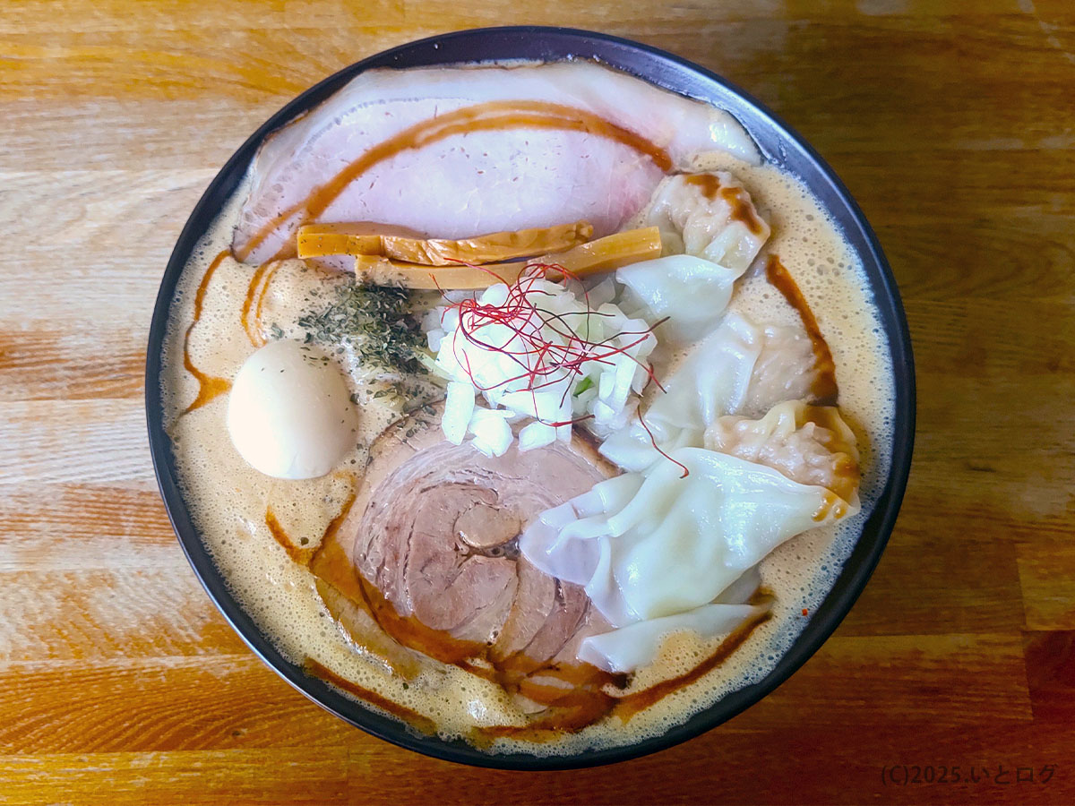 真上から見た泡系スープの得製ラーメン。ワンタン・味玉・極太メンマが彩り良く並ぶフォトジェニックな一杯。