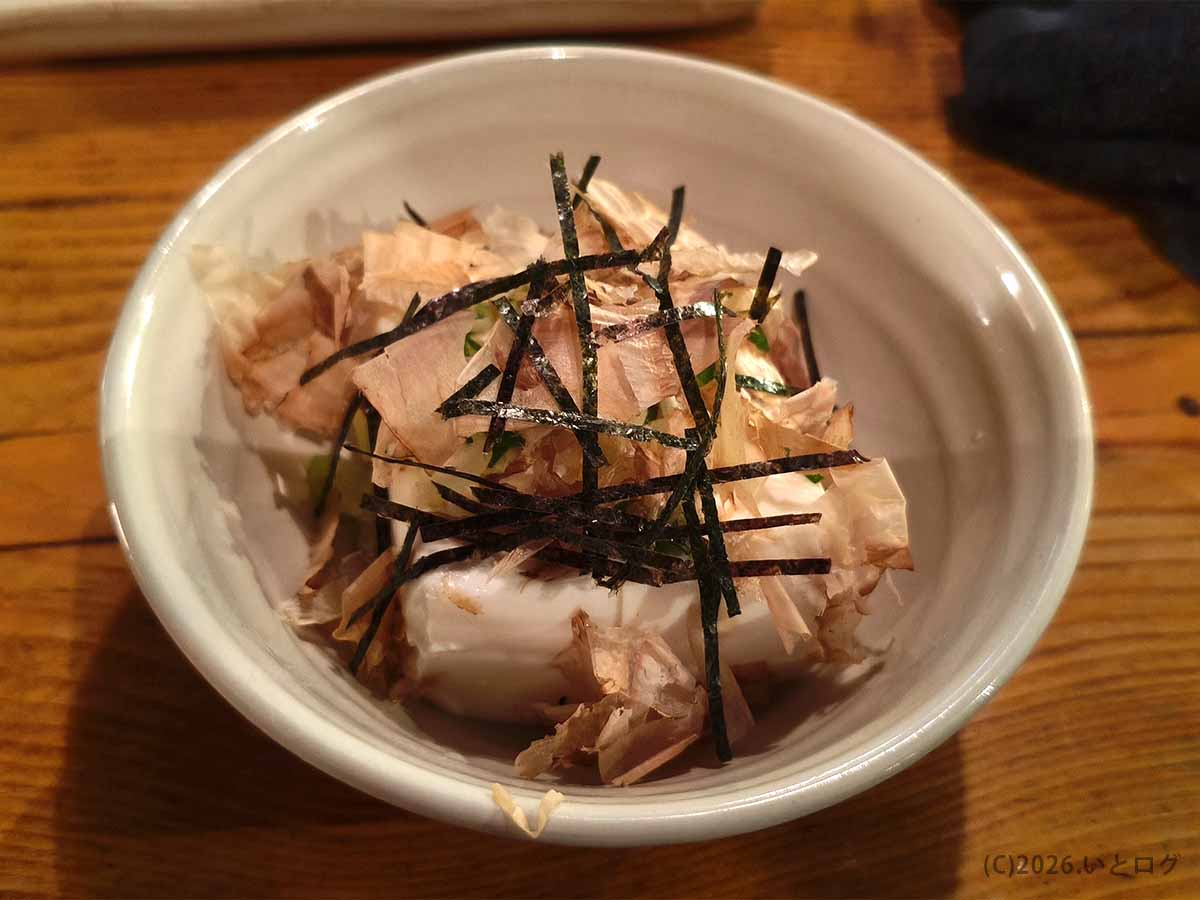 釧路の炉ばたで提供された冷奴。白い器に盛られた豆腐に、かつお節と刻み海苔がたっぷりとのせられている