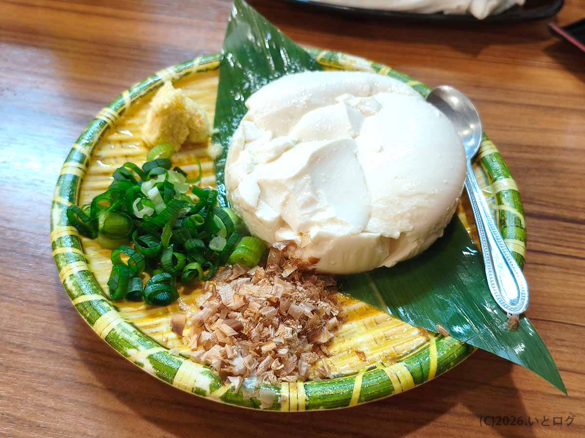 帯広の魚の一心で注文した十勝産一心冷奴。丸く厚みのある固めの豆腐に、刻みネギ、かつお節、おろし生姜が添えられている。