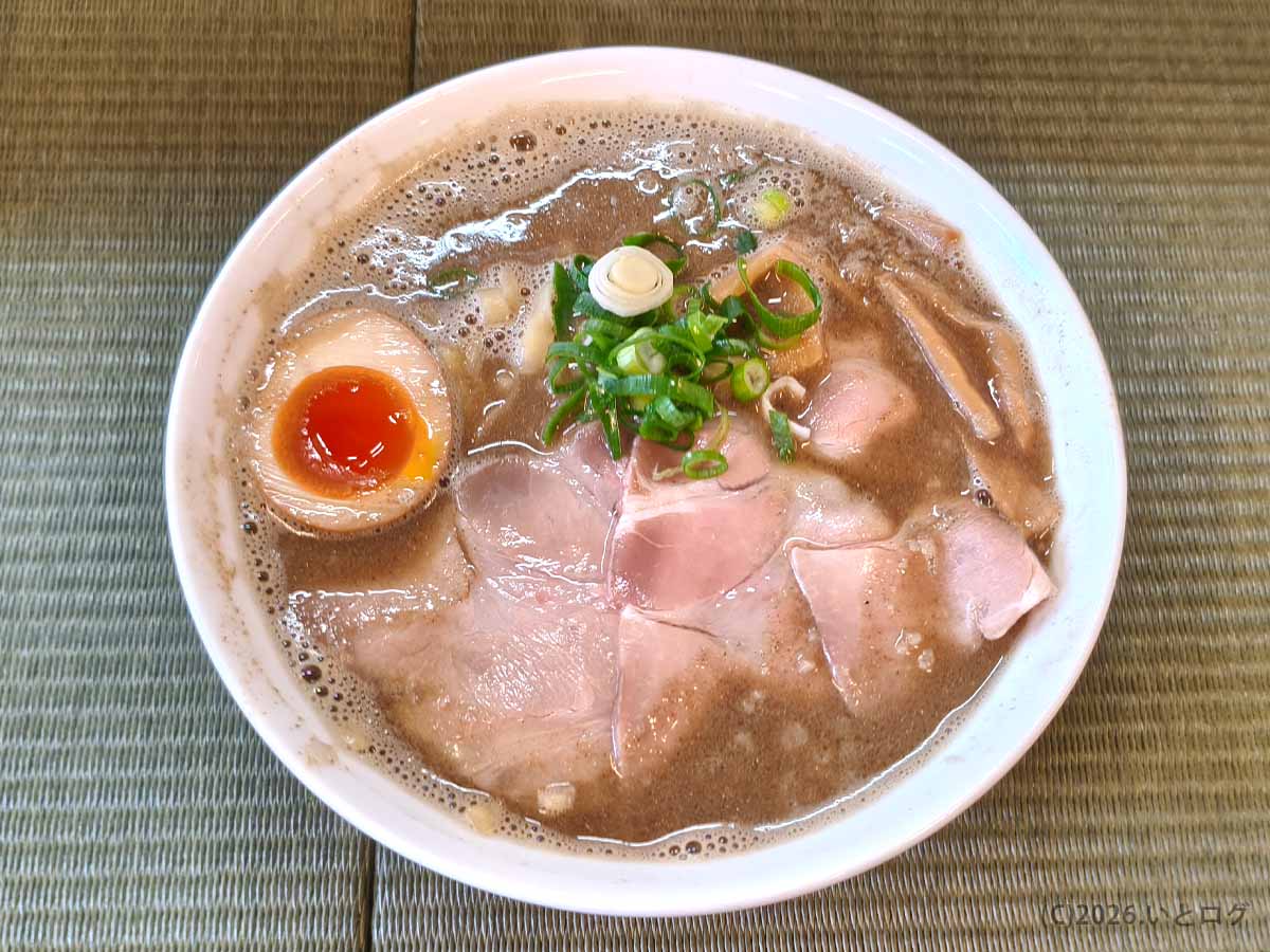 観音寺市の人気ラーメン店・伊吹いりこセンターの濃厚伊吹そば。泡立ついりこスープに味玉、チャーシュー、ネギ、メンマが入った一杯