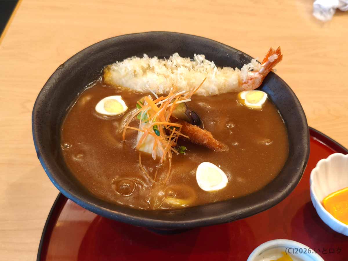 玉川 豊橋広小路本店で提供される、海老天や野菜、うずら卵がのった豊橋カレーうどん