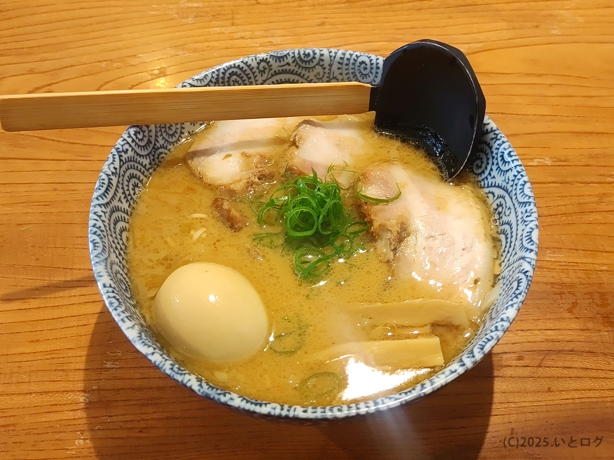 学園天空の味玉ラーメンを真上から。透き通る黄金色のスープにチャーシューと青ネギが映える、松江天空おすすめの一杯。