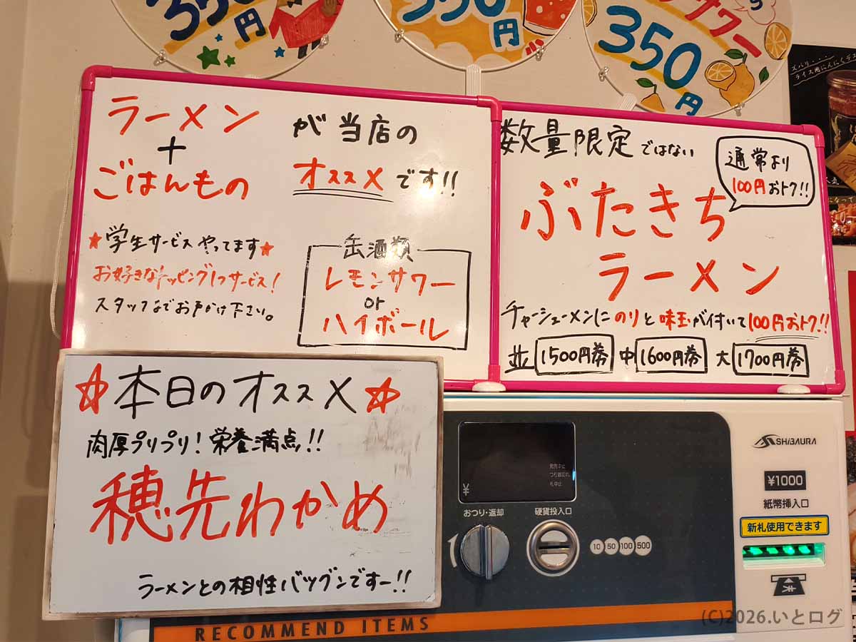 とらきち家の券売機横に掲示された、ご飯ものやぶたきちラーメン、穂先わかめなどのおすすめメニュー案内