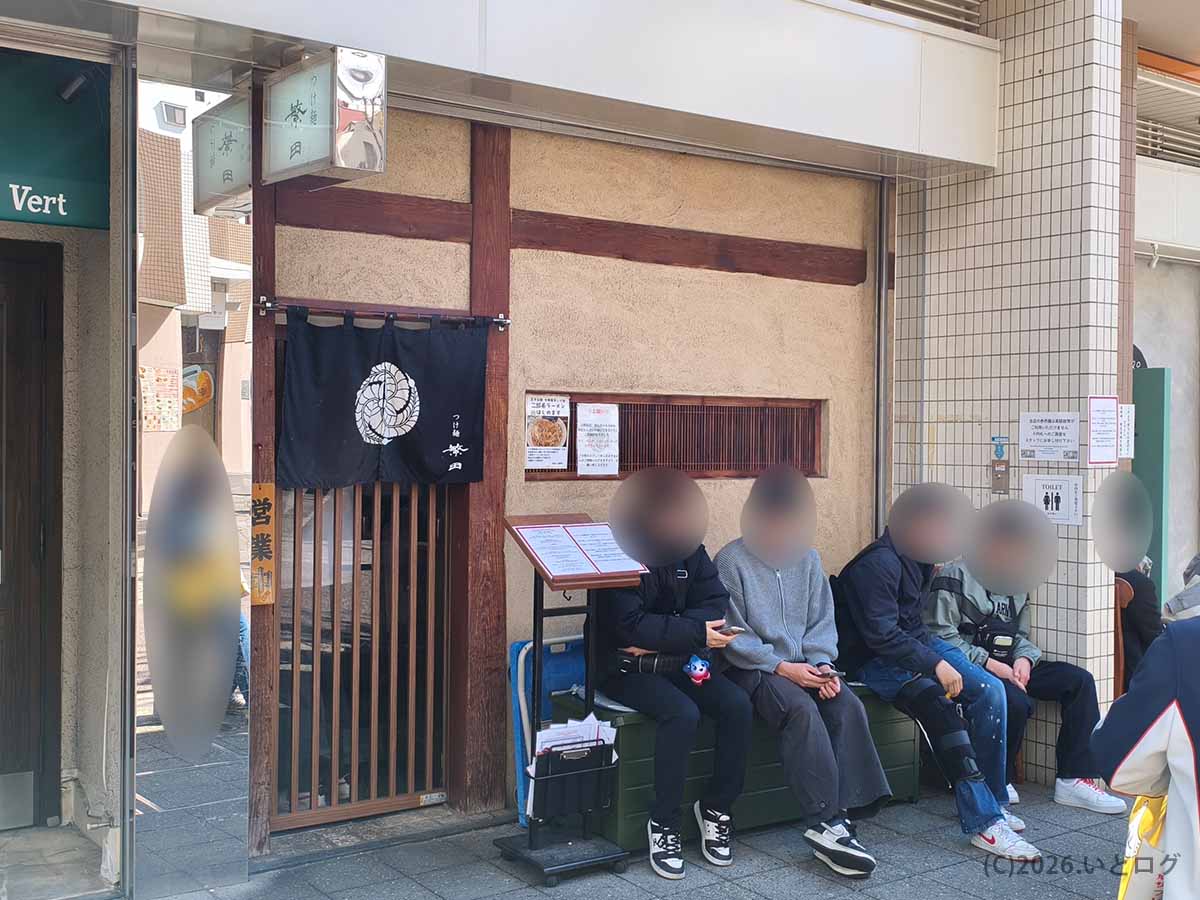 兵庫県神戸市灘区の六甲道にあるつけ麺 繁田の店舗前で、開店を待つ客が並んでいる様子