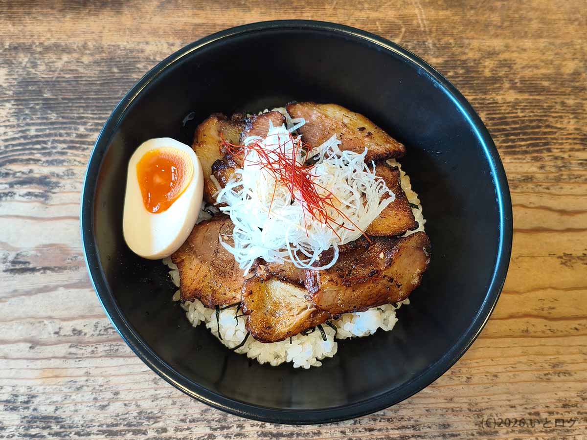 香ばしく焼かれたチャーシューに白髪ねぎと糸唐辛子、味玉を添えた甲府市・上田屋のチャーシュー丼