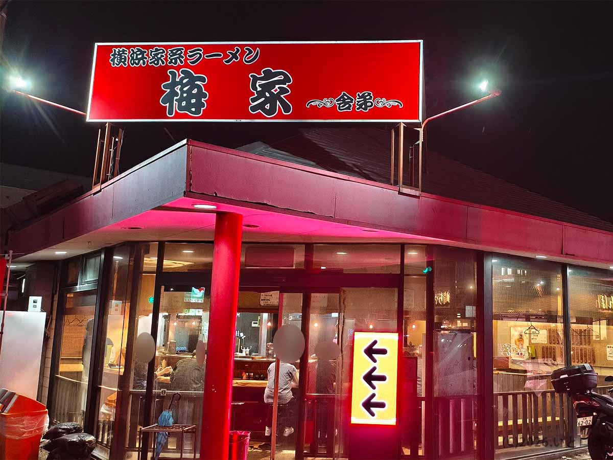 神奈川県厚木市にある横浜家系ラーメン「梅家 舎弟」の赤い看板が目立つ夜の店舗外観