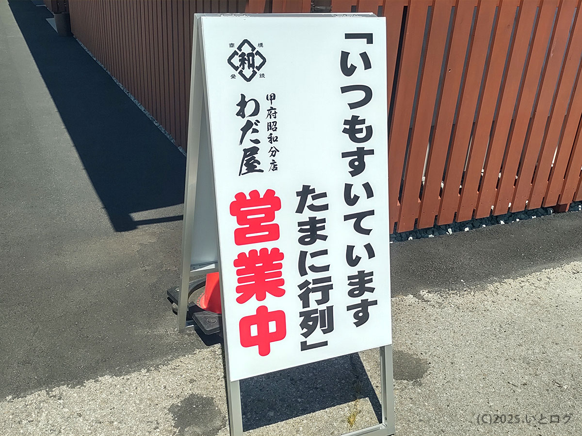 店頭の立て看板「いつもすいています たまに行列／営業中」。和田屋 ラーメンのわだ屋 甲府昭和分店の目印