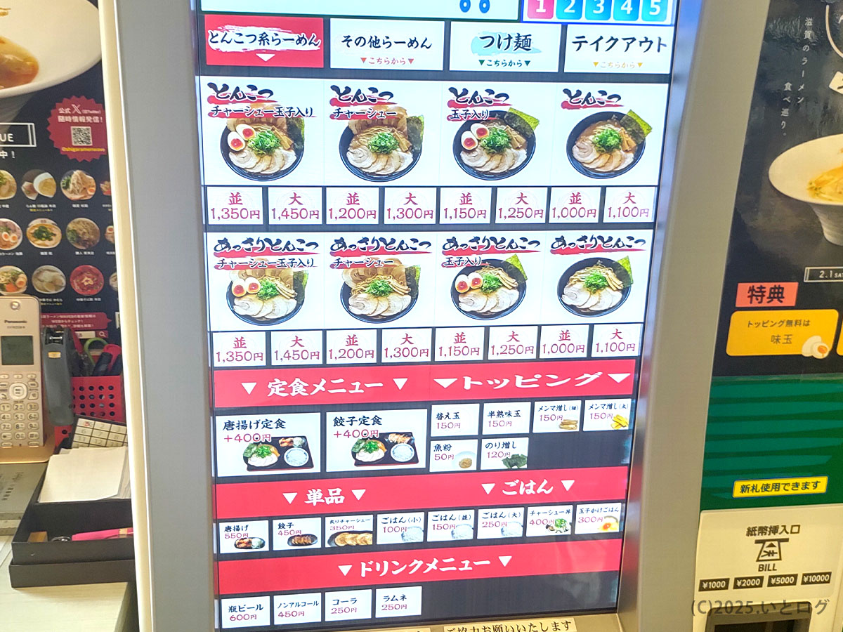 店内の券売機タッチパネル画面。人気のとんこつ豚そばやあっさりとんこつを並・大サイズから選べ、唐揚げ定食や餃子定食、ごはんもの、トッピングなどが写真付きで一覧表示されている。